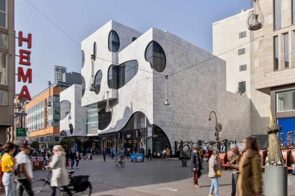 a group of people walking on a street in front of a building at COVE Centrum in The Hague