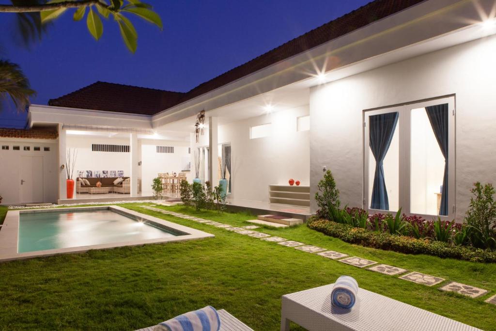 a house with a swimming pool in a yard at Villa Casablanco in Seminyak