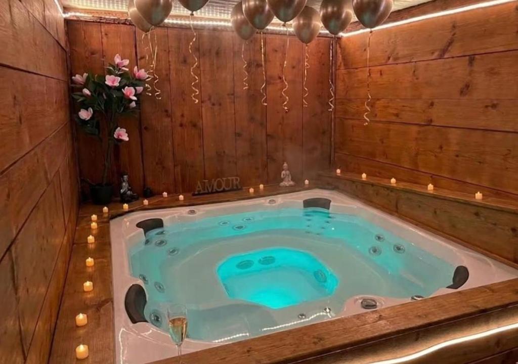 a jacuzzi tub in a wooden room with candles at Doux Pavillon - Sauna - Jacuzzi in Tassin-la-Demi-Lune