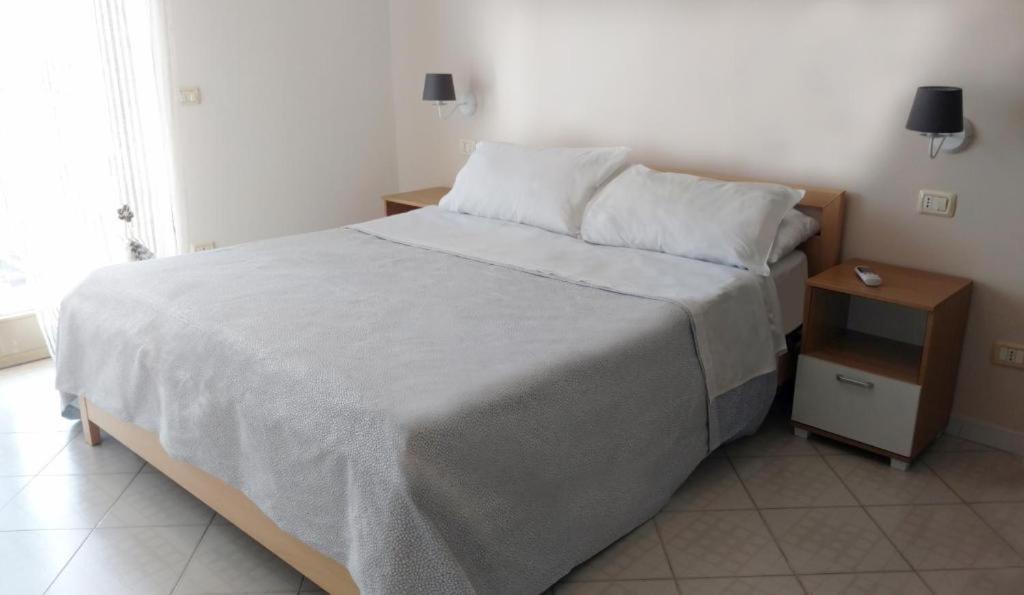 a bedroom with a large bed and a night stand at Sant'Agostino Apartment in Catanzaro