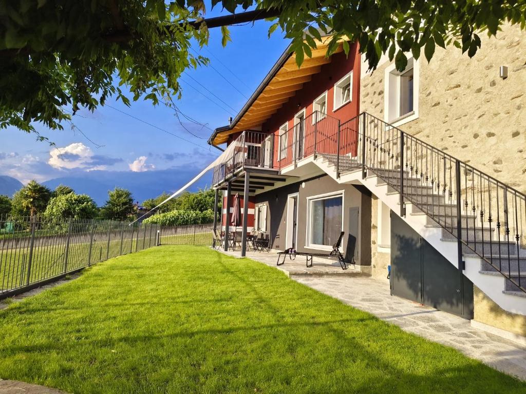 a house with a staircase and a lawn at Il Roncaccio Residence Colico in Colico