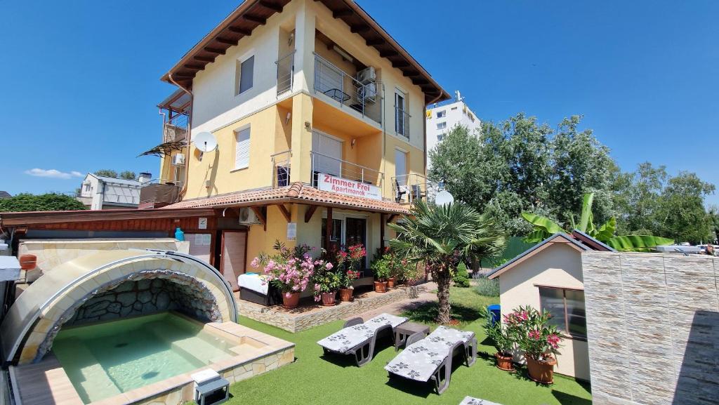 a house with a swimming pool in front of it at Napsugár Resort in Siófok