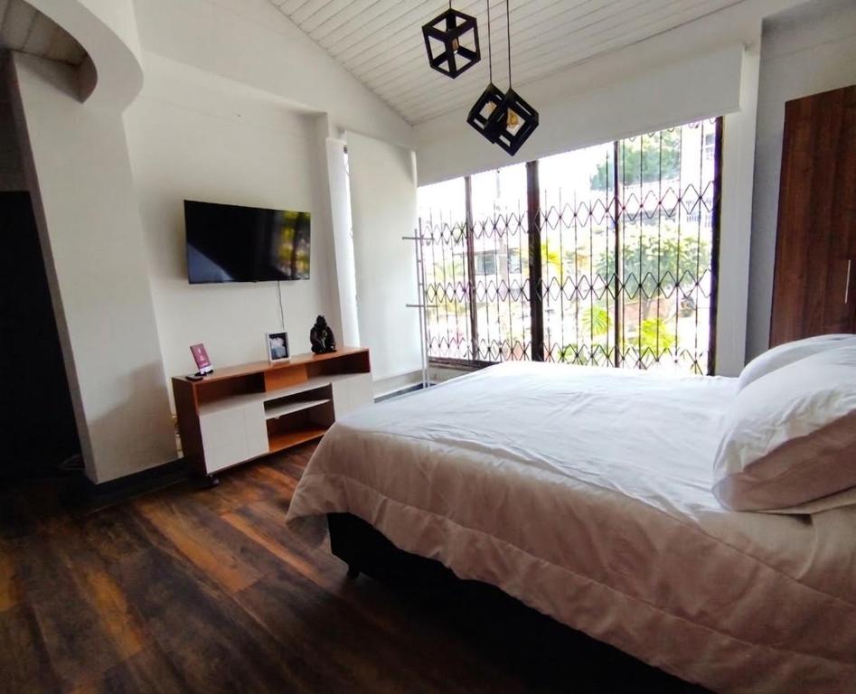 a bedroom with a bed and a large window at Textileria in Pereira