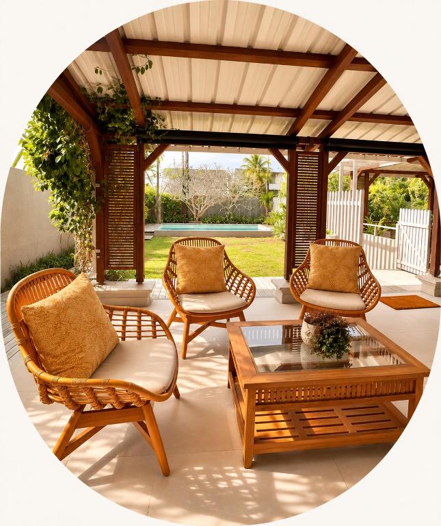 a patio with wicker chairs and a coffee table at Villa Kanasuk in Pointe d'Esny