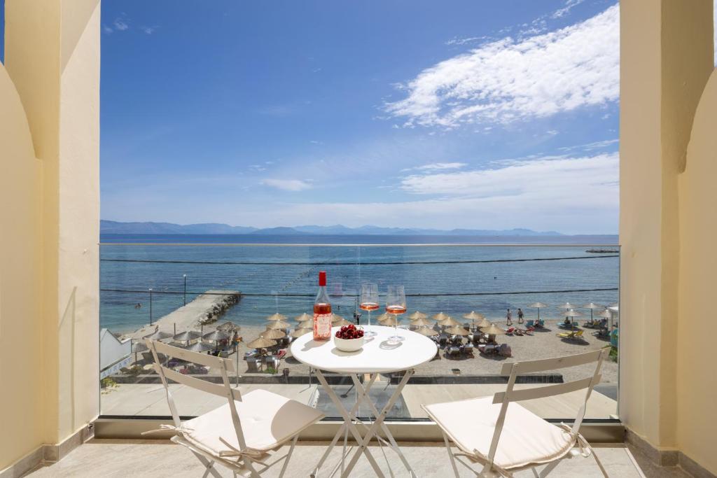 a table and chairs with a view of the ocean at Aeloria Boutique Hotel Corfu in Benitses