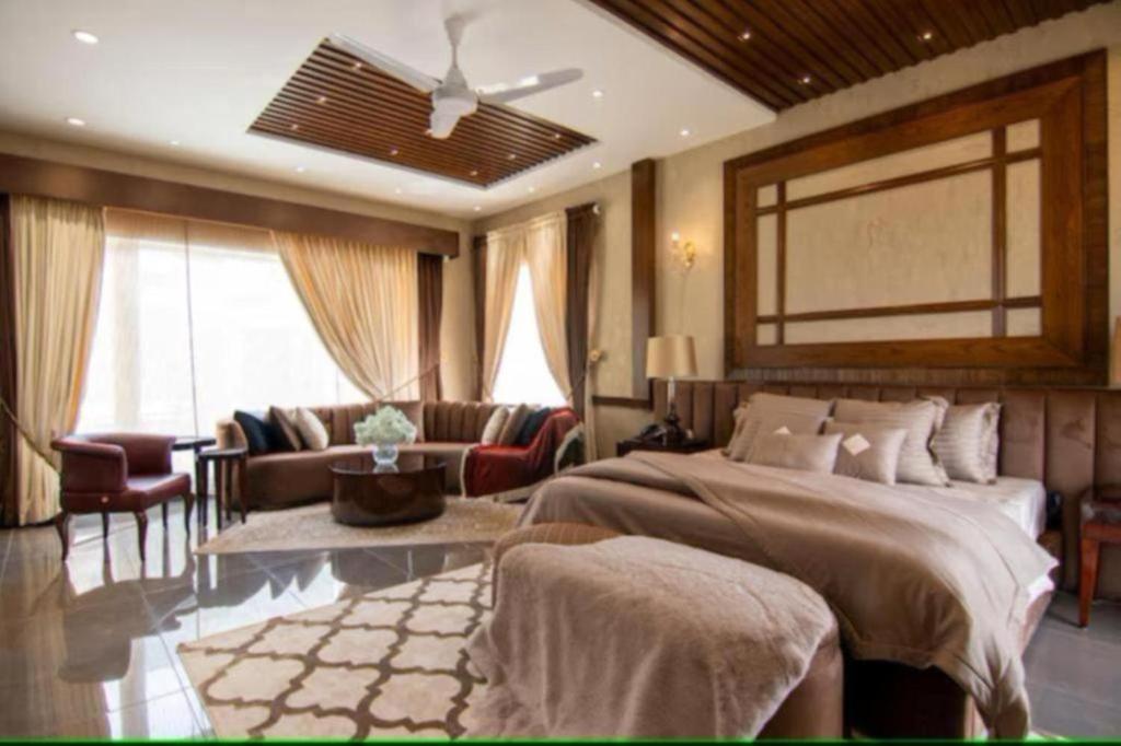 a bedroom with a bed and a living room at Hotel Elysian By G K Group Near IGI Delhi Airport in New Delhi