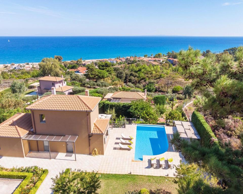 an aerial view of a house with a swimming pool and the ocean at Villa Ilias in Skala
