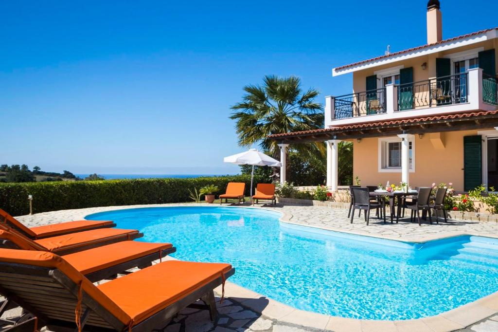 a villa with a swimming pool in front of a house at Villa Zeus in Spartià