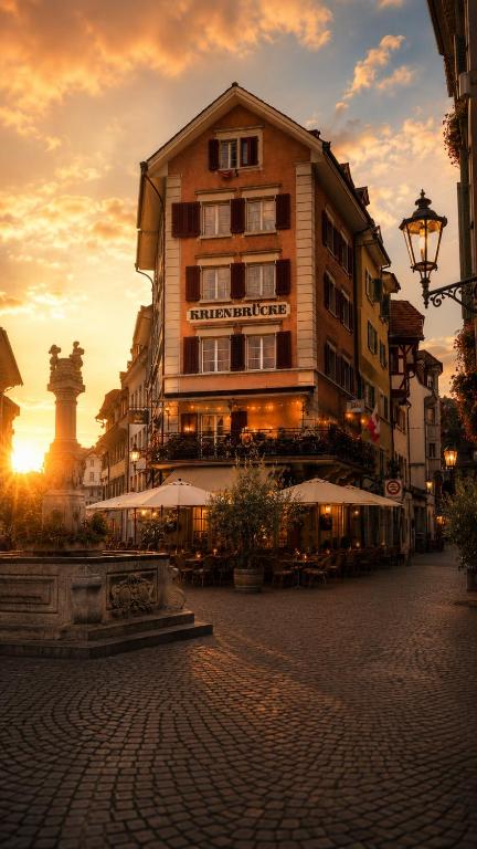 a building on a street with the sunset in the background at KB CityRooms Self-Check-In in Lucerne