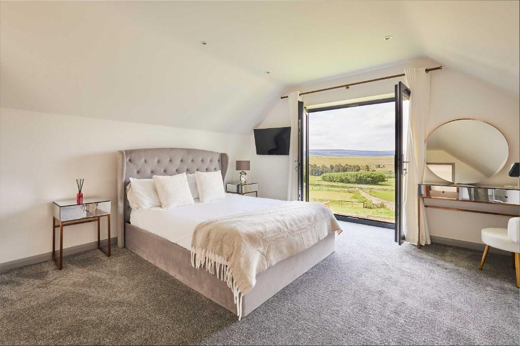 a bedroom with a large bed and a large window at Host & Stay - Thistle Cottage in Rochester