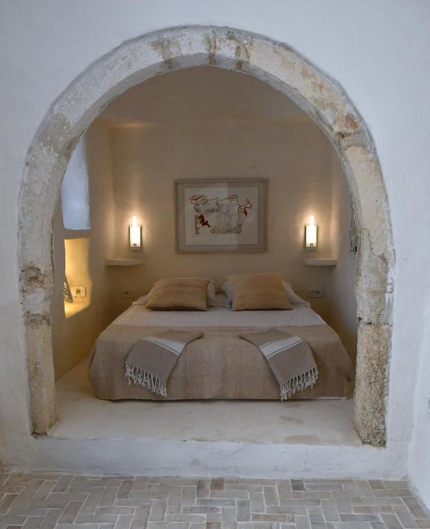 a bedroom with a large bed with an archway at Dar Bibine in Erriadh
