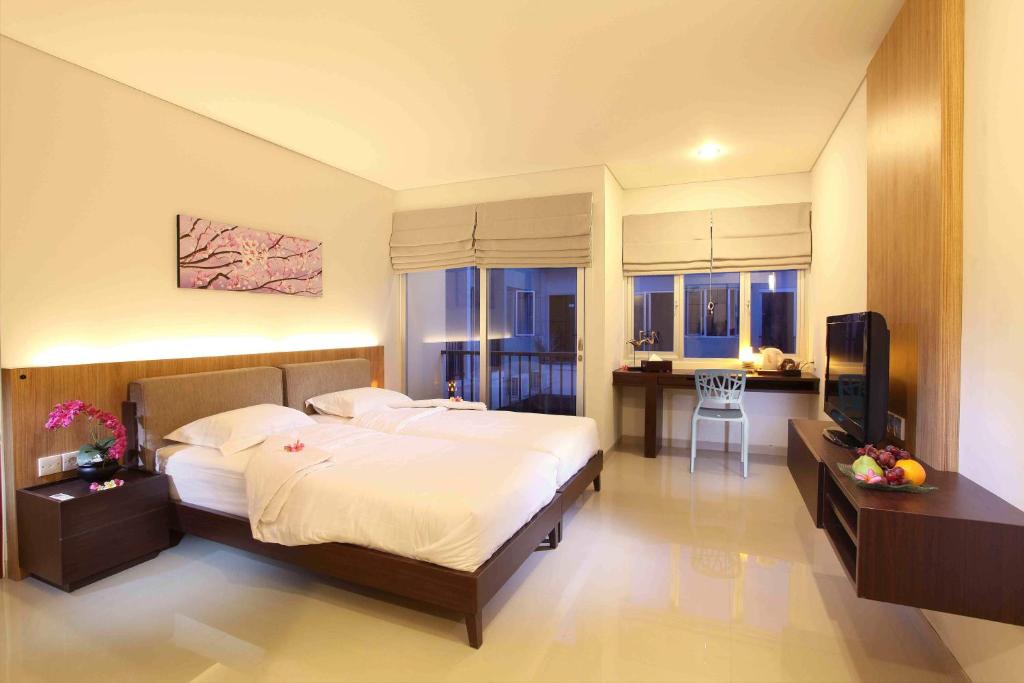 a bedroom with a bed and a television in it at Mi Casa Residence in Seminyak