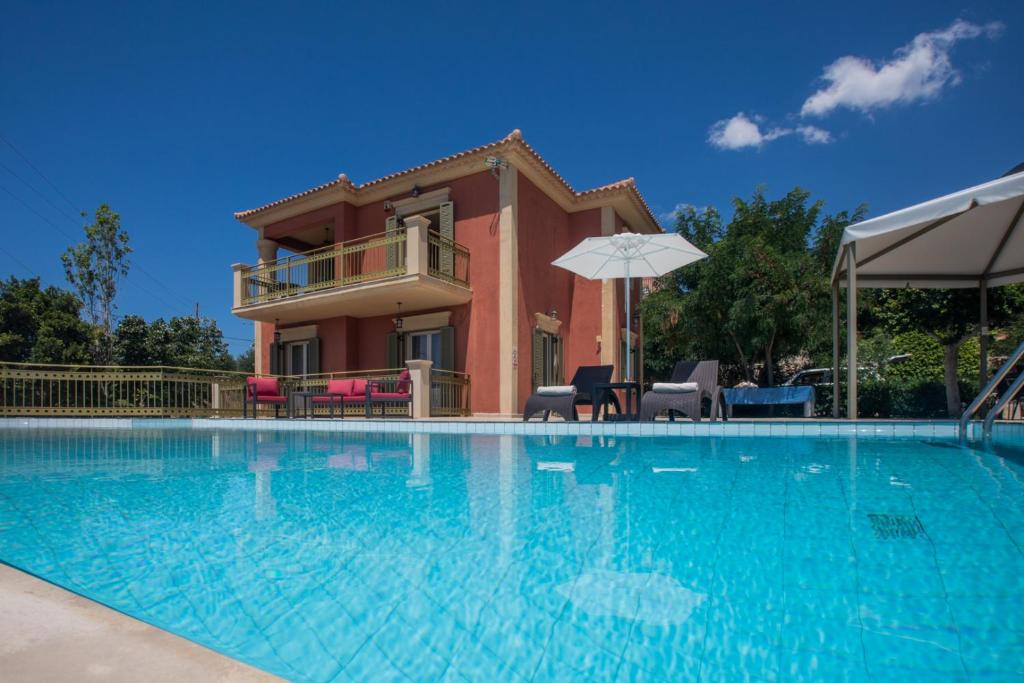 a large swimming pool with a house in the background at Lourdas Beach View by Villa Select in Lourdata
