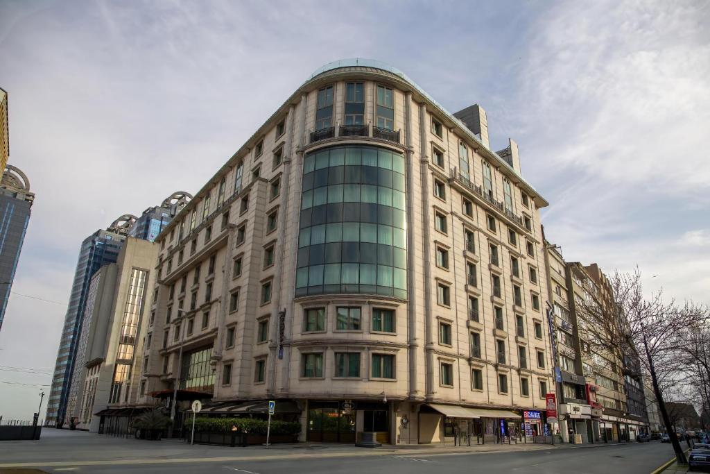 a large building with glass windows on a city street at Radisson Blu Hotel, Istanbul Sisli in Istanbul