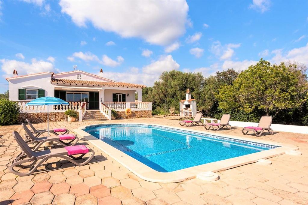 a swimming pool with chairs and a house at Villa Son Domingo by Villa Select in Alaior