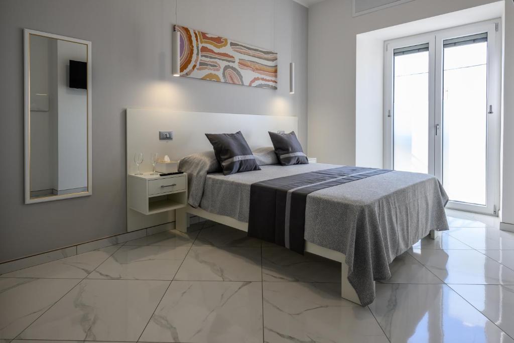 a bedroom with a large bed and a mirror at Al 211 Rooms in Pizzo