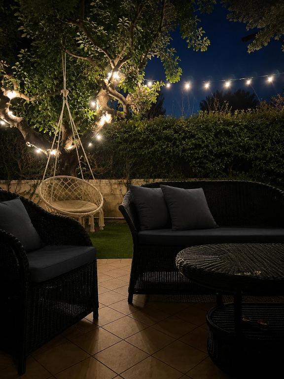 a patio with two chairs and a swing at night at Villa Fabi in Brindisi