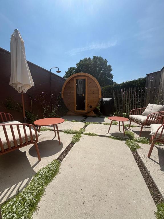 a group of picnic tables and an umbrella in a backyard at Ferox Stay in Varsenare