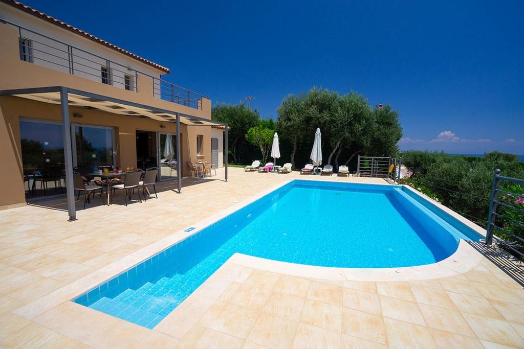 a swimming pool in front of a house at Villa Joya by Villa Select in Skala