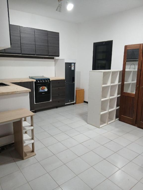 a kitchen with a stove and a white tile floor at L'hospitalité in Thies