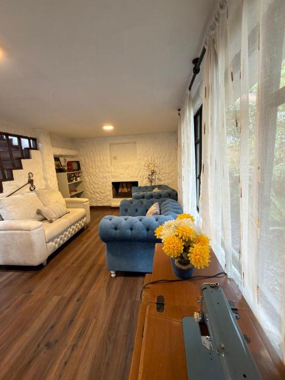 a living room with a couch and a table with flowers at Vereda San Jorge Chalet in Zipaquirá