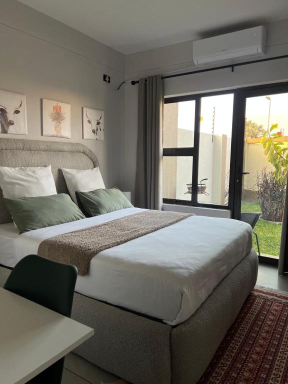 a bedroom with a large bed and a window at Ekuku Snug in Oshakati