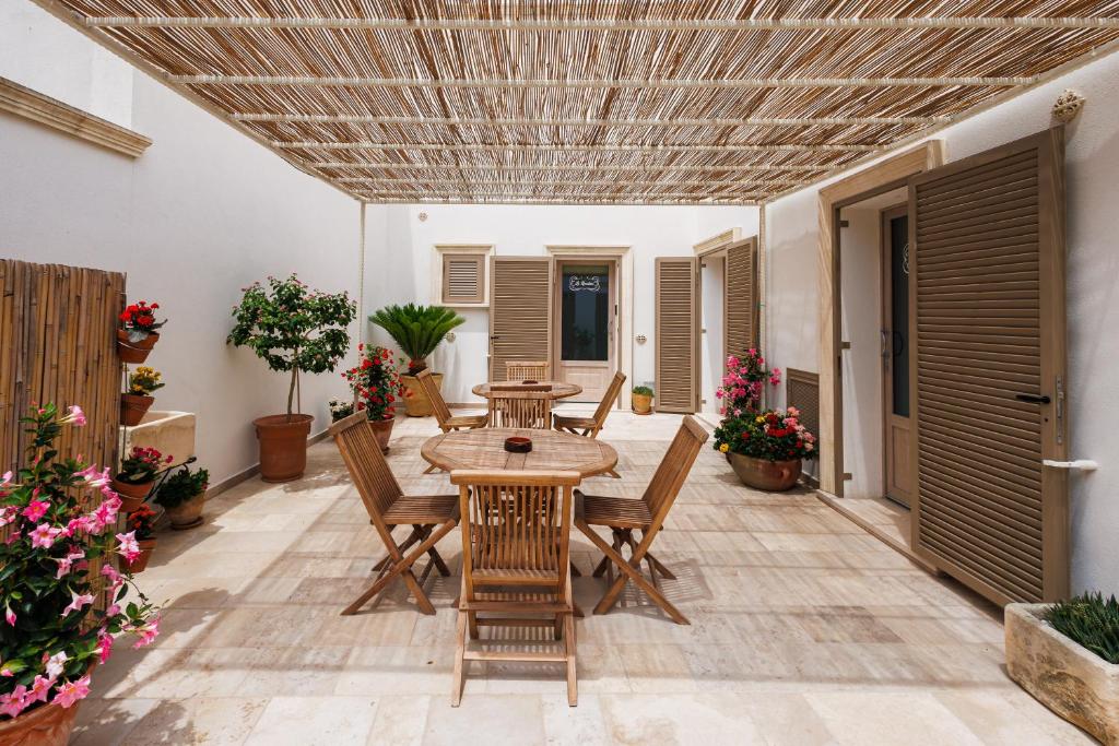 a patio with a wooden table and chairs at Miria B&B in Castrignano del Capo