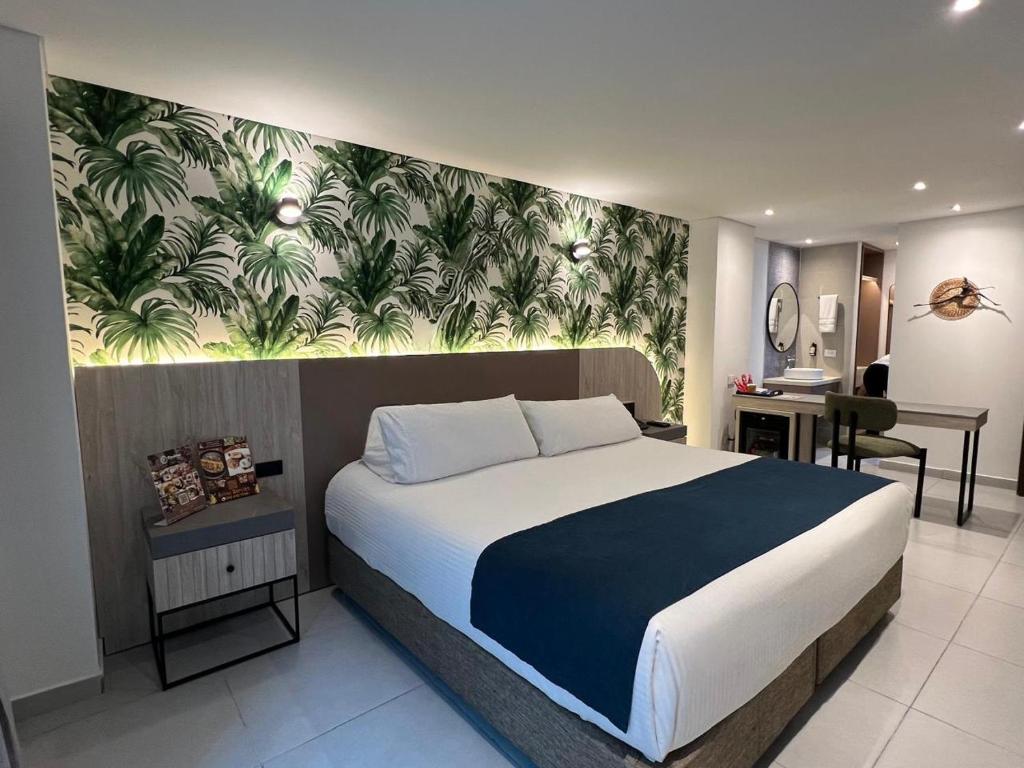 a bedroom with a large bed with a painting on the wall at Zi One Luxury Hotel in Pereira