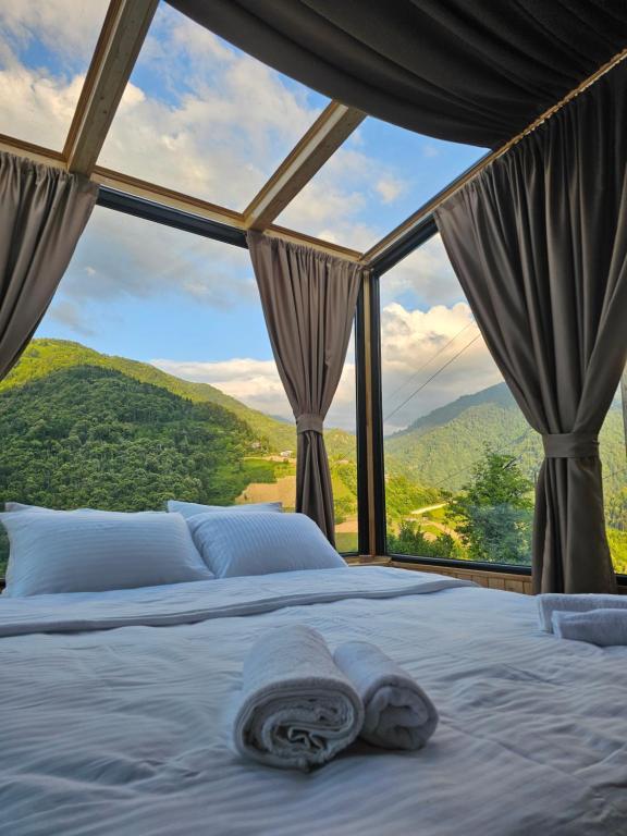 a bed in a room with a large window at Merisi Horizon 2 in Silibauri