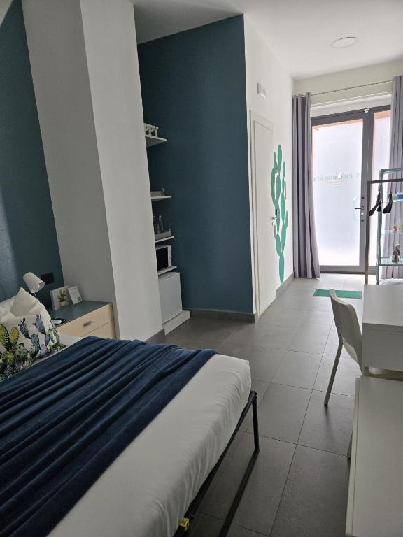 a bedroom with a bed and a blue wall at fico d'india in Spadafora