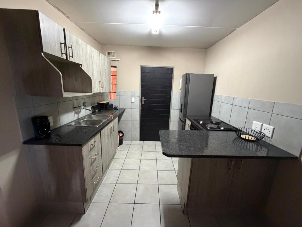 a small kitchen with a sink and a refrigerator at Zoe in Centurion