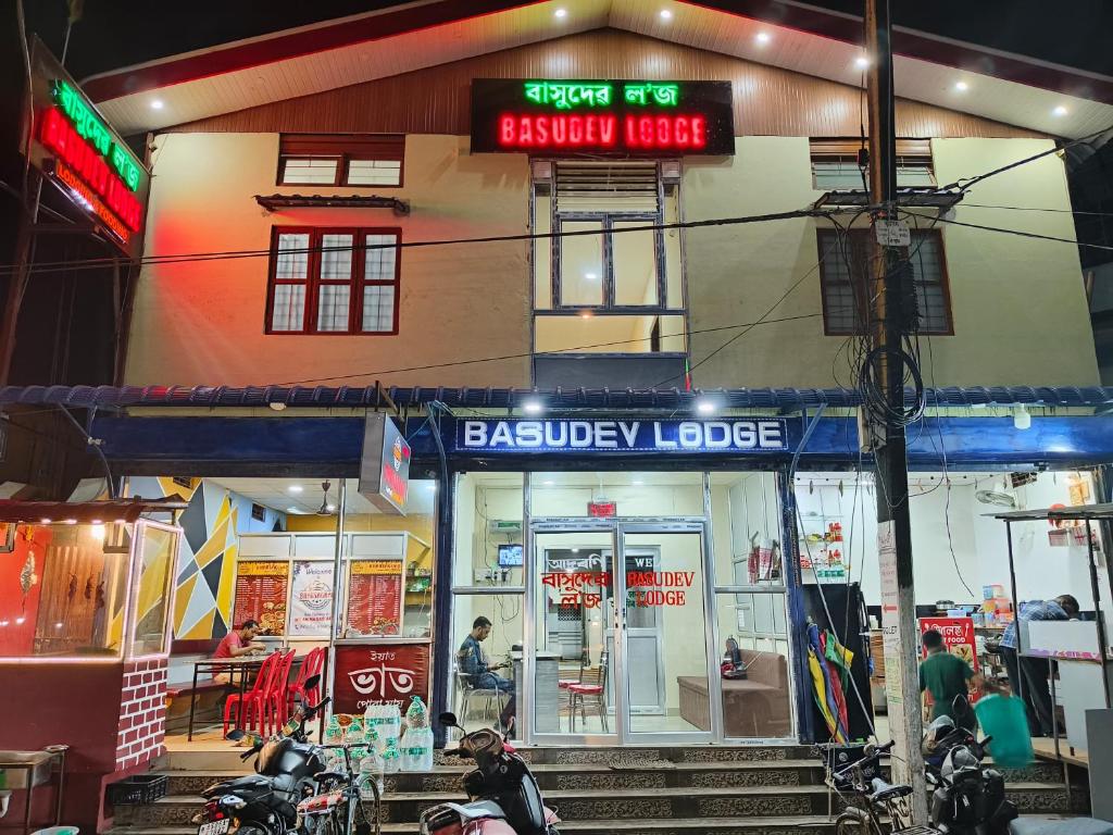 a building with a bakery lobby with motorcycles parked outside at Basudev Lodge in Dibrugarh