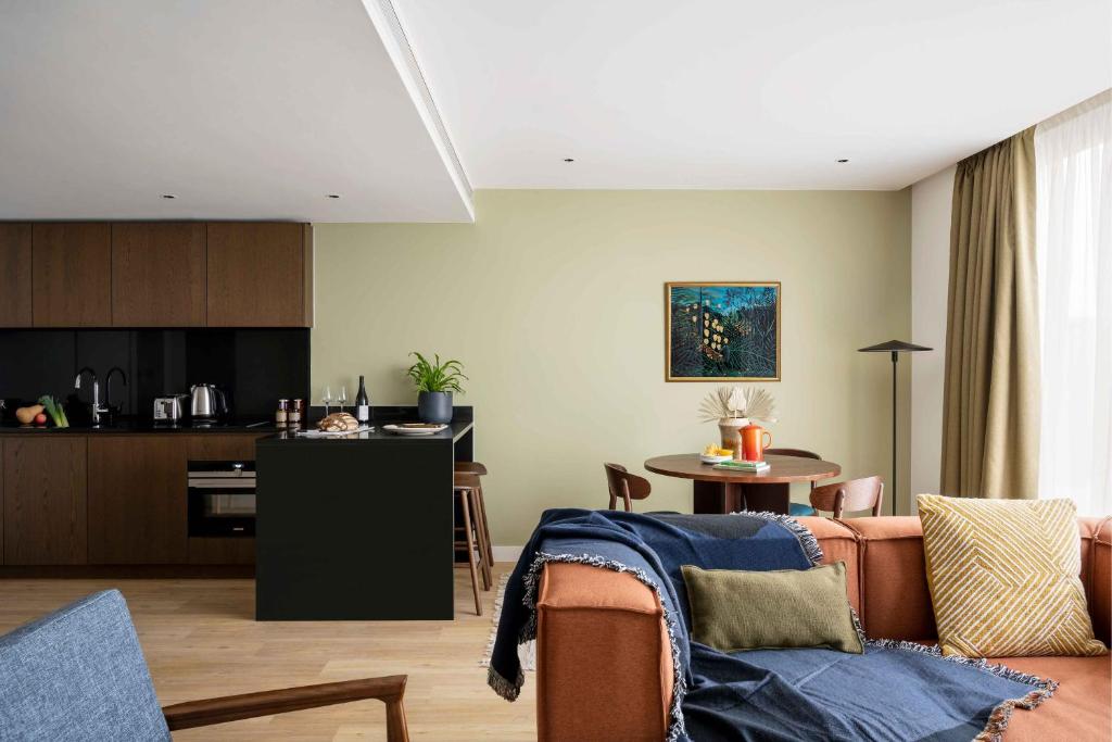 a living room with a couch and a kitchen at Cove Landmark Pinnacle in London