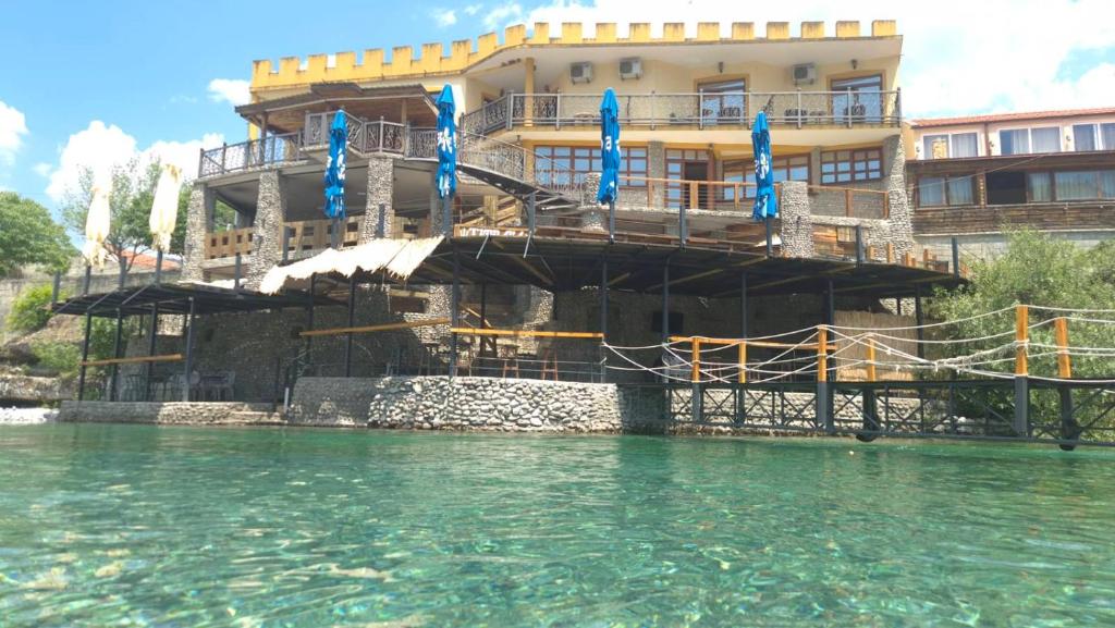 a building sitting on the water in front of a building at Castle waterfront apartments in Dinoša