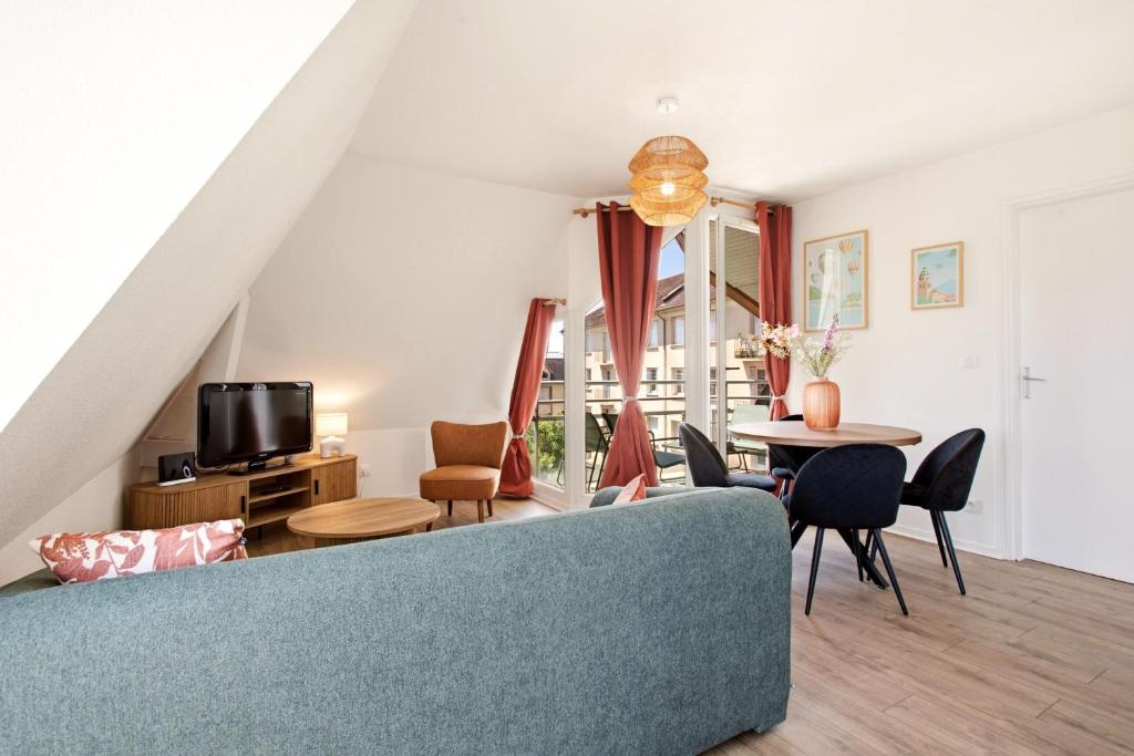 a living room with a couch and a table at Le Calmette - Balcon, Parking & Ascenseur in Caen