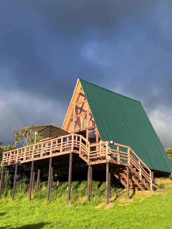 a large wooden house with a green roof at Monte Waïa in Guasca