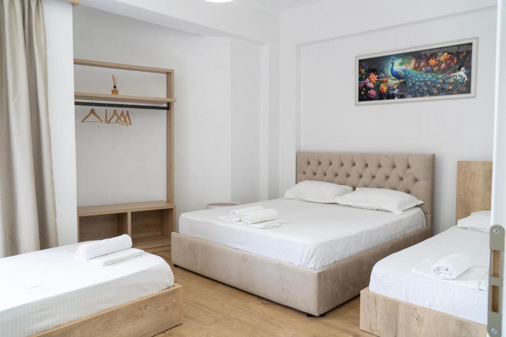 a bedroom with two beds and a painting on the wall at B&B Sunny Side in Sarandë