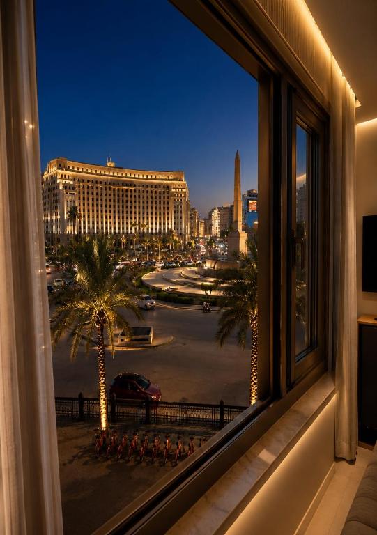 a window with a view of a city at night at Royal Town Hotel in Cairo