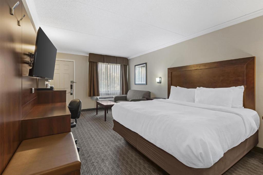 a hotel room with a large bed and a television at Best Western Plus Dryden Hotel and Conference Centre in Dryden