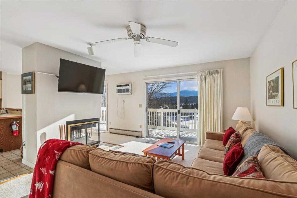 a living room with a couch and a tv at Mountainside Condo J202 in Stowe