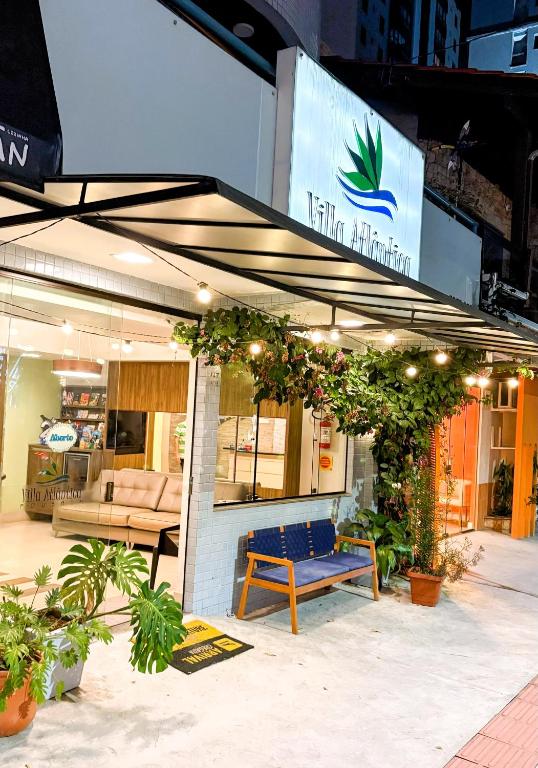 a store front with a blue bench and plants at Pousada Villa Atlântica in Balneário Camboriú