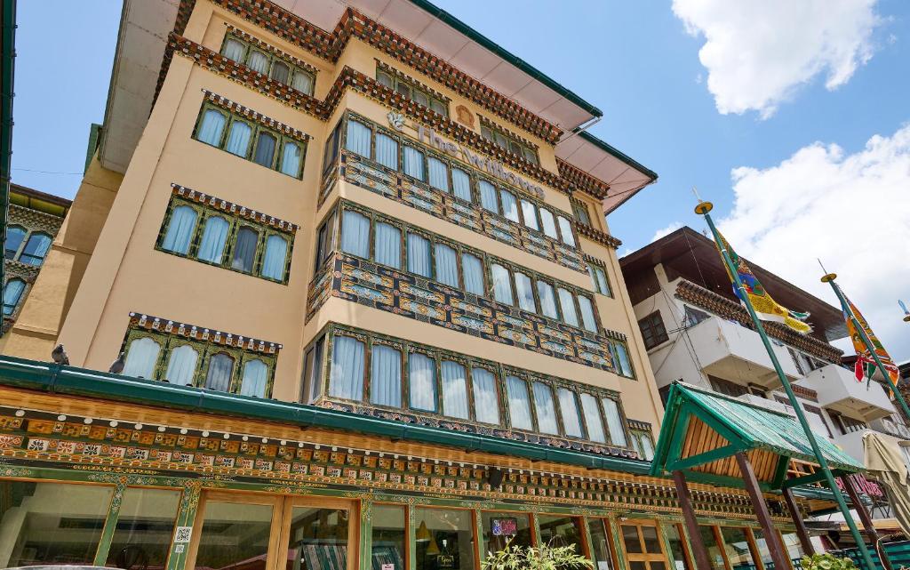 a tall tan building with a lot of windows at The Willows Hotel, Bhutan in Thimphu