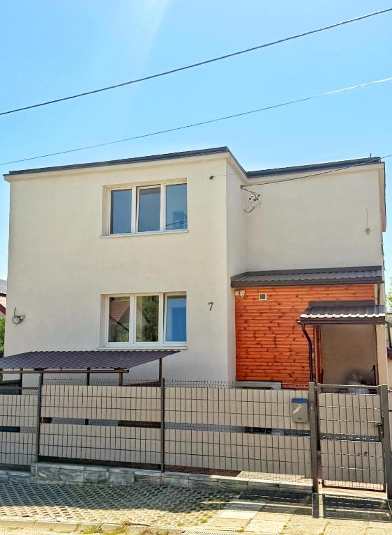 a white house with a fence in front of it at Górna Residence&Rooms in Grudziądz
