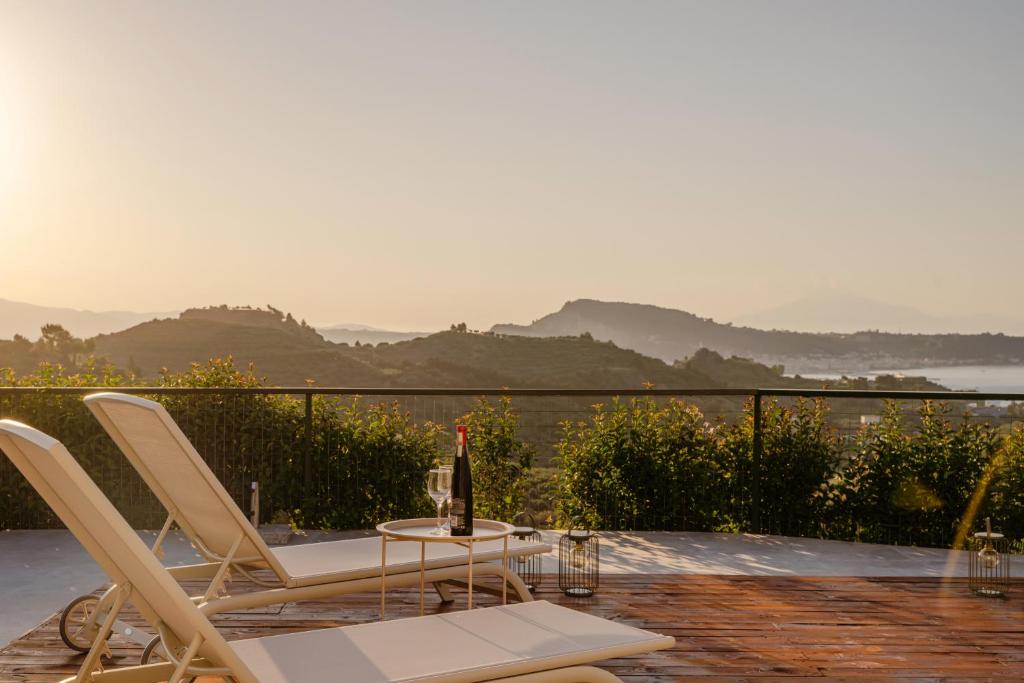 a table and chairs on a patio with a bottle of wine at Seamar View Zante in Argassi