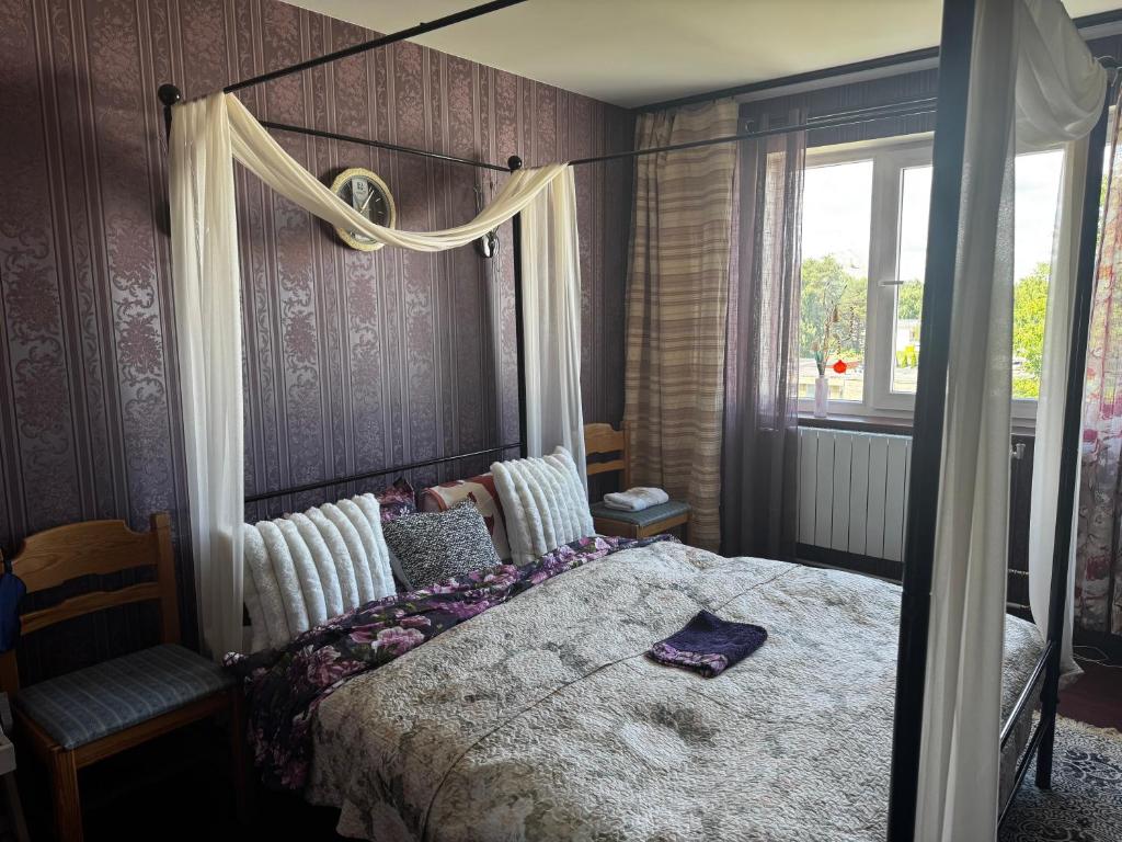 a bedroom with a canopy bed and a window at Romantic Studio Suite with Sauna in Pyussi
