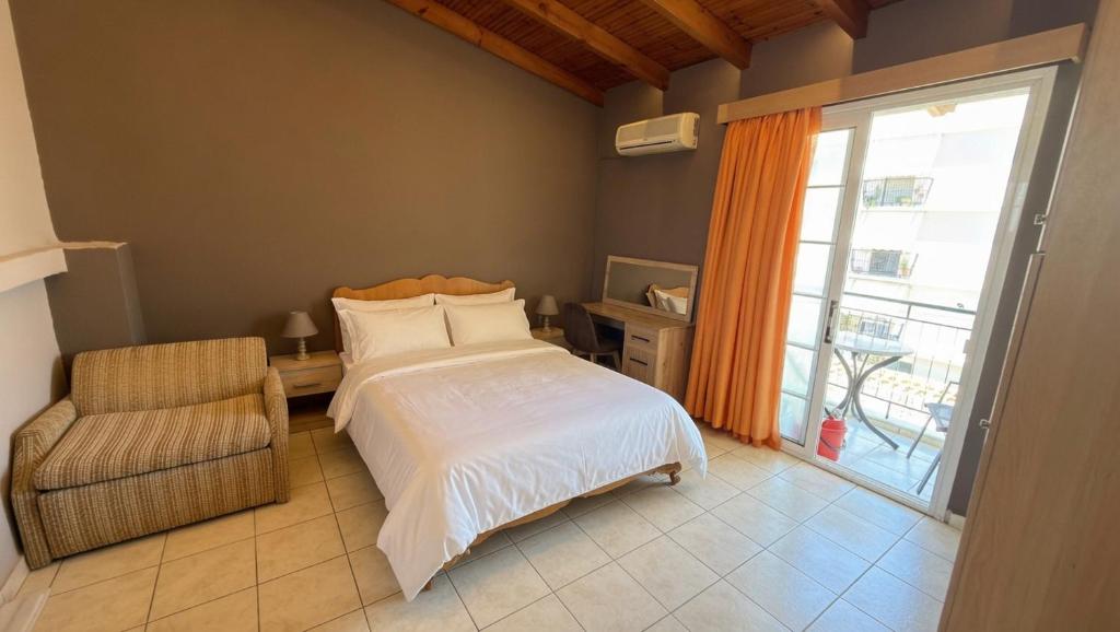 a bedroom with a bed and a chair and a window at Kalamata Penthouse By PAVLOS in Kalamata