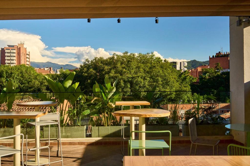 a patio with tables and chairs and a view of a city at beminimal jardines in Medellín