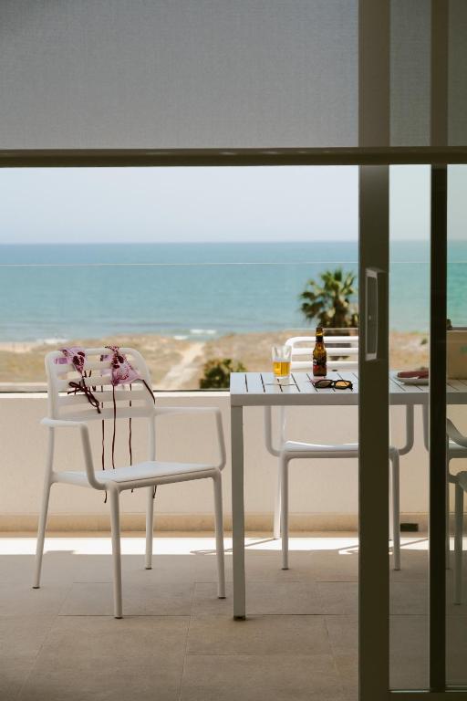 a table and chairs with a view of the beach at Almar Suites Daimús in Daimuz