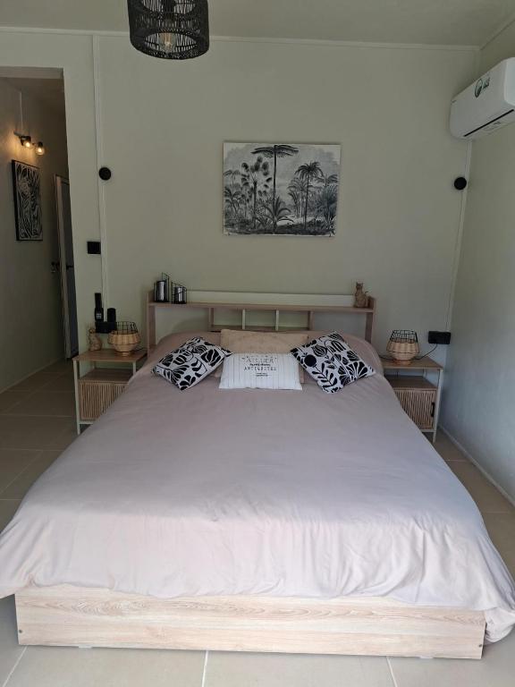 a large white bed in a room with two tables at Kot Ory Mountain View Studio in Moka