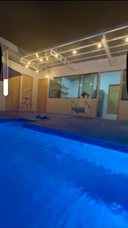 a swimming pool at night with blue lighting in a house at Casa Isabella in Ángeles